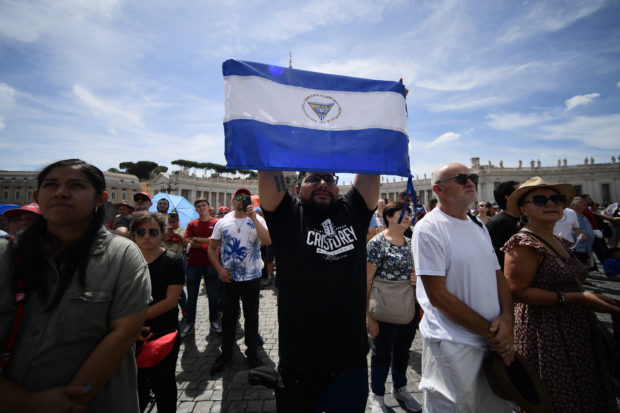 A man holds the national flag of Nicaragua at St. Peter's square during the Pope's weekly Angelus prayer on August 21, 2022 in The Vatican. (Photo by Filippo MONTEFORTE / AFP)