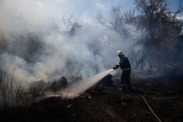 A firefighter tries to put out a wildfire near Algyo, Hungary, July 14, 2022. Farmers across Hungary have reported "historic" drought damage affecting some 550,000 hectares of land, the ministry of agriculture said this month. REUTERS/Marton Monus