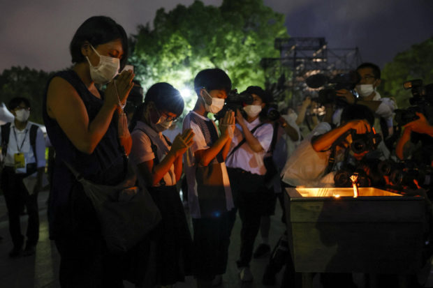 People pray in front of the cenotaph for the victims of the 1945 atomic bombing, on the 77th anniversary of the world's first atomic bombing, at Peace Memorial Park in Hiroshima, western Japan, August 6, 2022, in this photo taken by Kyodo. Mandatory credit Kyodo via REUTERS
