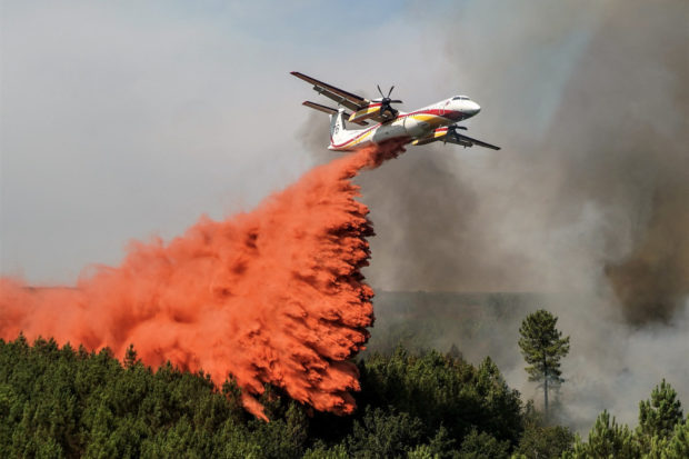 A firefighting aircraft drops flame retardant to extinguish a wildfire near Hostens, as wildfires continue to spread in the Gironde region of southwestern France