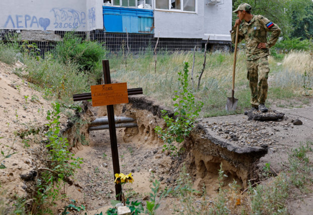 People in Ukraine town dig up hastily buried bodies for proper funeral