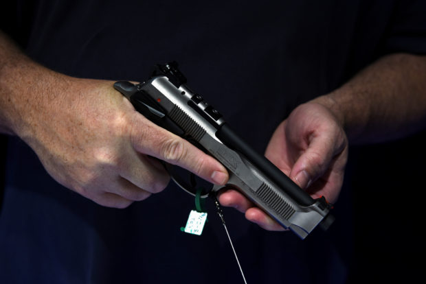 FILE PHOTO: An attendee holds a handgun on display at the National Rifle Association (NRA) annual convention in Houston, Texas, U.S. May 29, 2022. REUTERS/Callaghan O'Hare