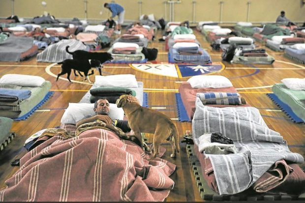 Homeless people rest with their animals during low temperatures in Canoas, Brazil. STORY: Beds for their pets entice homeless to stay indoors