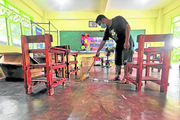 Ehgy Boy Quilonio, a graduate of Dagupan City National High School in Pangasinan, volunteers to clean his former classroom in preparation for next week’s school opening. STORY: DepEd rules out extension of enrollment period