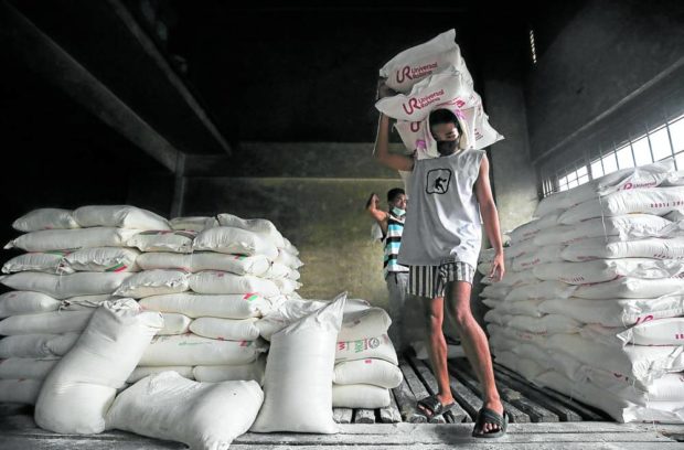 Workers haul flour at a bakery supplies warehouse in Pasig City
