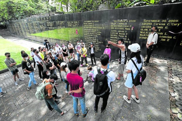 NEVER FORGET Addressing youths visiting the Bantayog ng mga Bayani for the first time on Sunday, activist Jay-R Reyes talks about the many Filipinos who sacrificed their lives in the struggle against martial rule, including the late former Sen. Benigno “Ninoy” Aquino Jr. (inset) whose death anniversary was commemorated on Sunday. 