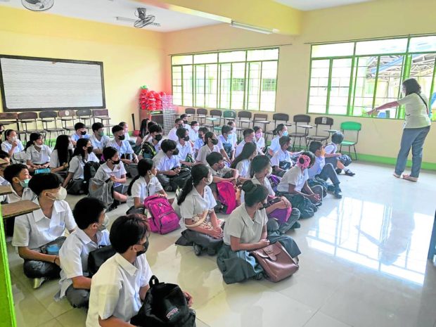 Grade 7 students in Manila’s Jose Abad Santos High School sit on the floor on their first day back on campus although a school official tells the Inquirer there are enough chairs for all their students. STORY: Gridlock, fewer PUVs as schools reopen