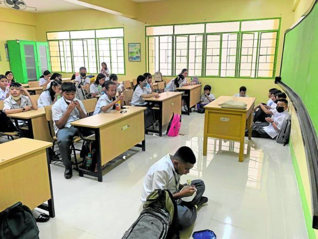 DAY ONE SITUATION Due to lack of chairs, seven Grade 7 students take their snacks on the floor inside their classroom at Jose Abad Santos High School in Manila in this photo taken around 10 a.m. during recess on Monday, the first day of the school year. —Jane Bautista