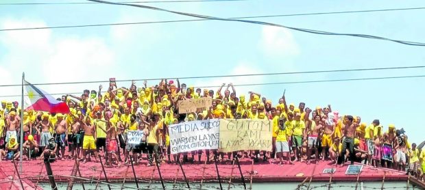 ROOFTOP PLEA   Inmates at Iloilo District Jail in Pototan town on Wednesday stay for almost nine hours on a building rooftop to protest against their jail warden. —PHOTO COURTESY OF ZARRAGA NEWS LIVE STATION