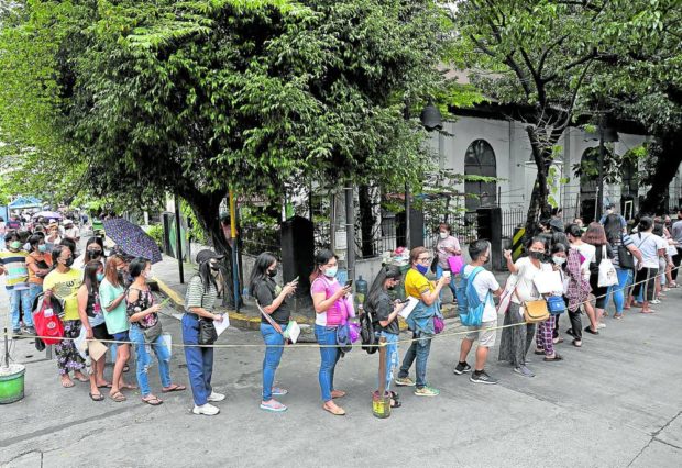 Beneficiaries of the educational assistance distributed by the Department of Social Welfare and Development (DSWD) form a more orderly queue outside the DSWD-NCR office in Sampaloc, Manila, which leads to a bigger crowd inside (right photo), still observing order, as personnel of the agency process their cash aid. —PHOTOS BY RICHARD A. REYES