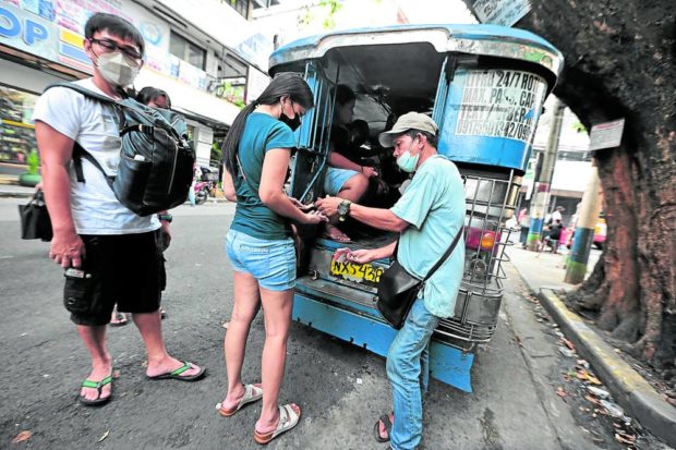 Passengers queue at a jeepney terminal in Manila on Monday. The Land Transportation Franchising and Regulatory Board next month will decide on a petition seeking to increase the current P11 minimum jeepney fare. STORY: LTFRB: Jeepney fares due for new increase