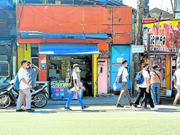 Residents of Cebu City still wear masks as they walk through Katipunan Street. STORY: ‘Freedom to choose:’ Face masks no longer required in Cebu City