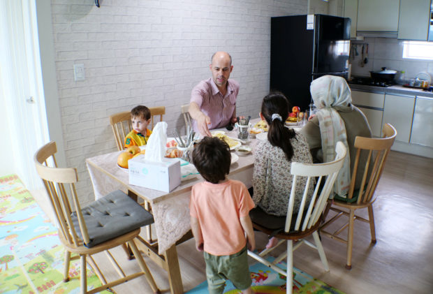 Shahpoor Ahmad Azimi eats lunch with his family at his house in Yongin