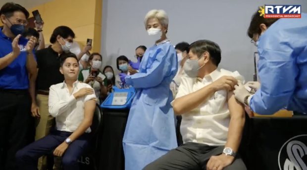 President Ferdinand "Bongbong" Marcos Jr. and son Ilocos Norte Rep. Sandro Marcos receive their booster shots during the PinasLakas vaccination campaign in Manila. Screengrab from RTVM