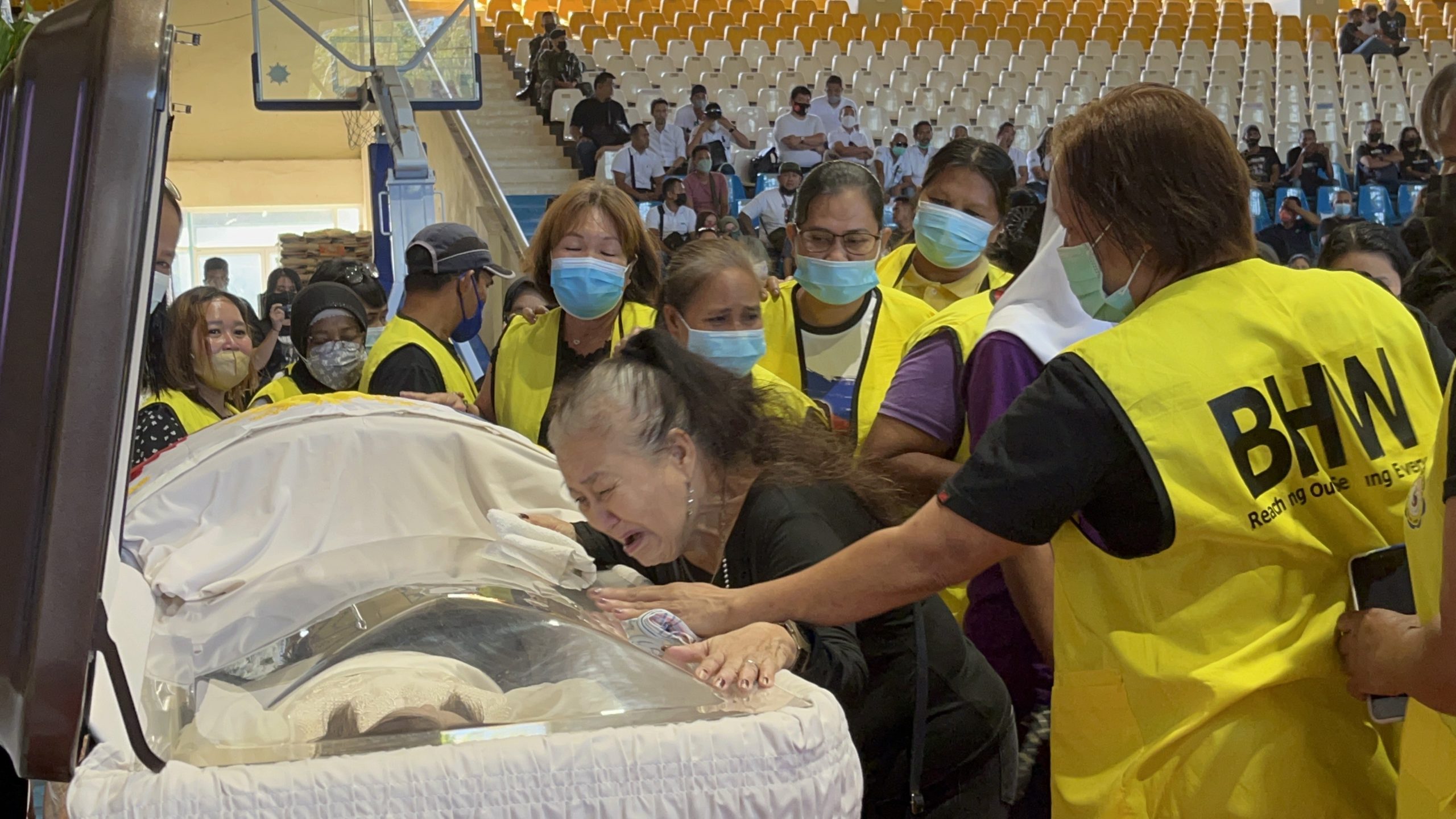 Fe Anglingco a BHW member, wept as she was trying to hug the coffin of slain former Lamitan City mayor Rosita Furigay