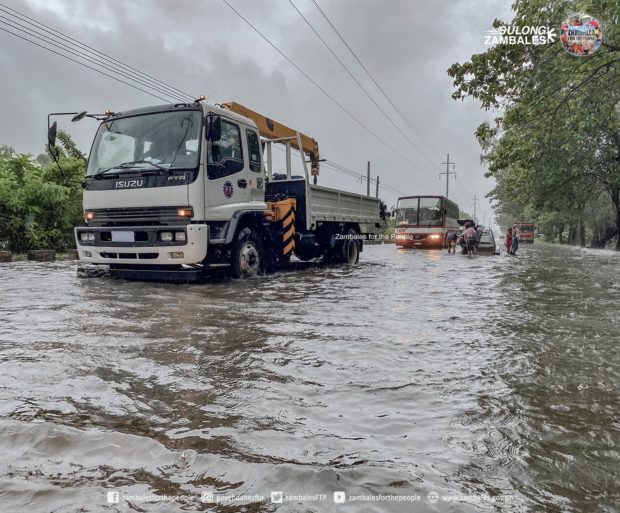 Several motorists in San Felipe, Zambales, were left with no choice but to push their vehicles amidst gutter-deep flood water brought by Florita PH. | PHOTO: Zambales for the People/Facebook