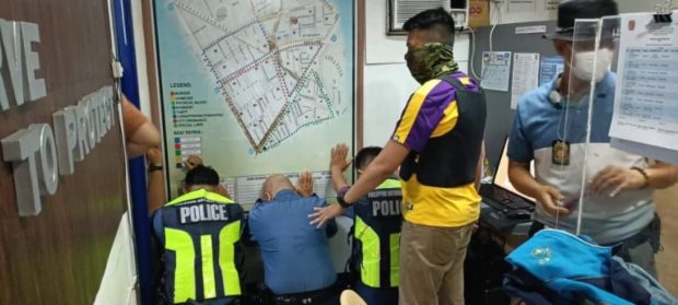 Personnel from the Philippine National Police - Integrity Monitoring and Enforcement Group arrest three officers at the Paco Police Community Precinct in Manila on Monday, August 15, 2022.