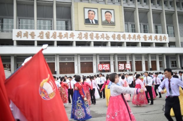 Youths and students dance at the plaza before the Pyongyang Indoor Stadium in Pyongyang on August 25, 2022 to mark the 62nd anniversary of their late leader Kim Jong Il's first field guidance to the revolutionary armed forces. (Photo by KIM Won Jin / AFP)