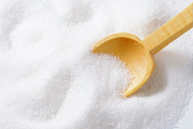 Stock photo close-up of sugar with a wooden spoon. STORY: Sale of smuggled sugar via Kadiwa hit