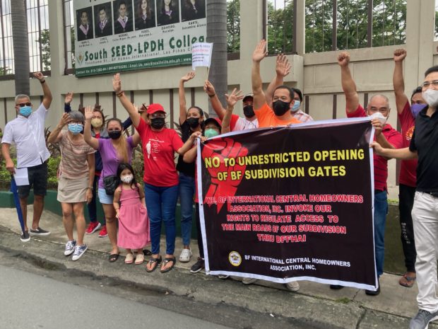 Protesters from 16 homeowner associations hold a rally along Tropical Avenue in BF Homes, Parañaque City, to denounce the Human Settlements Adjudication Commission’s order that allows the opening of the subdivision’s five gates to public and motorists. 