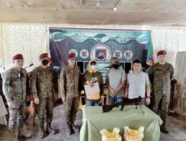 TIRED. A bomb-maker of the outlawed Bangsamoro Islamic Freedom Fighters, identified only as “Alias Rosbil,” (center) surrendered to the military with his Ultimax light machine gun claiming he was tired and wanted to live a normal life. (Army photo)