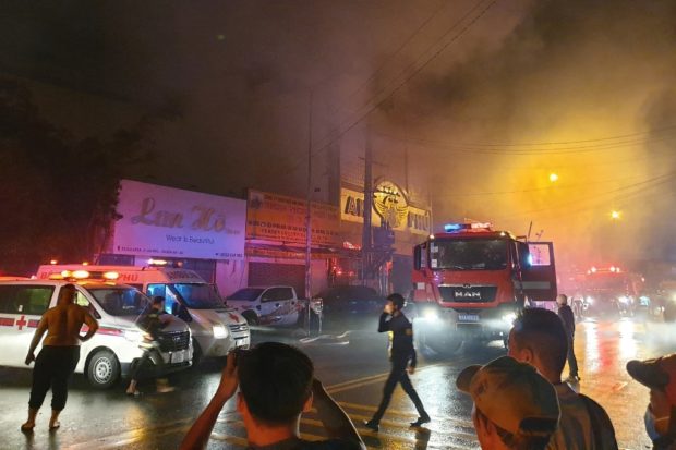 This picture taken on September 6, 2022 and released on September 7 by the Vietnam News Agency shows firefighters at the scene of a deadly fire that engulfed a karaoke bar in Binh Duong province, north of Ho Chi Minh City. - A fire tore through a karaoke bar in Vietnam killing 12 people and leaving 11 injured, a local official said September 7. (Photo by Vietnam News Agency / AFP)
