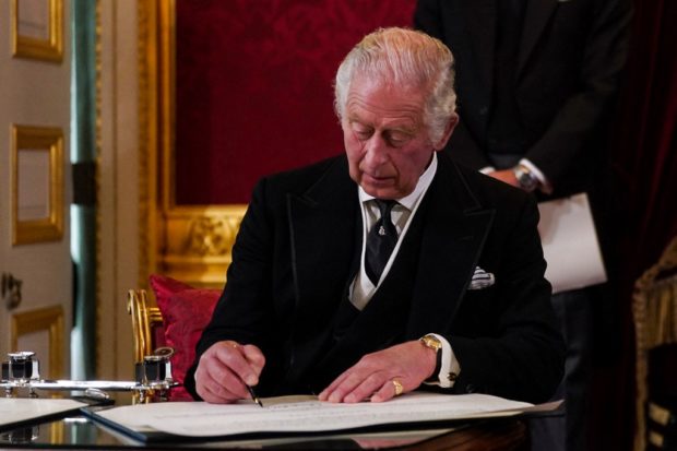 Britain's King Charles III signs an oath to uphold the security of the Church in Scotland, during a meeting of the Accession Council inside St James's Palace in London on September 10, 2022, to proclaim him as the new King. - Britain's Charles III was officially proclaimed King in a ceremony on Saturday, a day after he vowed in his first speech to mourning subjects that he would emulate his "darling mama", Queen Elizabeth II who died on September 8. (Photo by Victoria Jones / POOL / AFP)