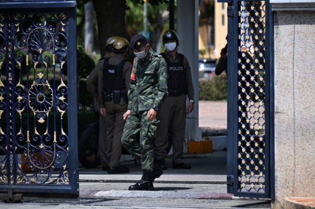 Policemen and army personnel patrol inside the gates after an alleged shooter was detained in the Army Training Command in Bangkok on September 14, 2022. - A gunman killed one person and wounded two others in a shooting at a military facility in Bangkok on September 14, 2022, Thai police told AFP. (Photo by Lillian SUWANRUMPHA / AFP)