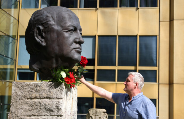 FILE PHOTO: A man places a rose on a sculpture of Mikhail Gorbachev in memory of the final leader of the Soviet Union, at the "Fathers of Unity" memorial in Berlin, Germany August 31, 2022. REUTERS/Lisi Niesner