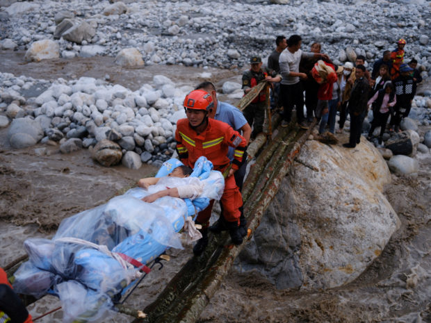 Rescue workers carry an injured victim on a stretcher following a 6.8-magnitude earthquake in Qinggangping village, Luding county, Ganzi Tibetan Autonomous Prefecture, Sichuan province, China September 5, 2022. China Daily via REUTERS