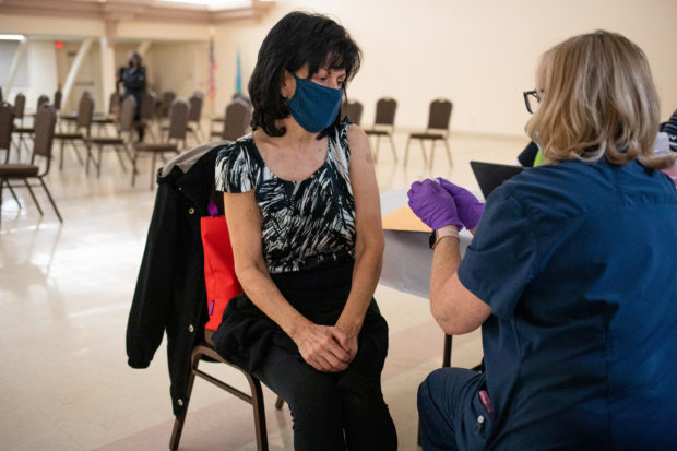 FILE PHOTO: A resident that is 50 years old and immunocompromised converses with the nurse after receiving a second booster shot of the coronavirus disease (COVID-19) vaccine in Waterford, Michigan, U.S., April 8, 2022.  REUTERS/Emily Elconin
