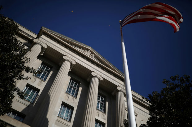 FILE PHOTO: An American flag waves outside the U.S. Department of Justice Building in Washington, U.S., December 2, 2020. REUTERS/Tom Brenner/File Photo