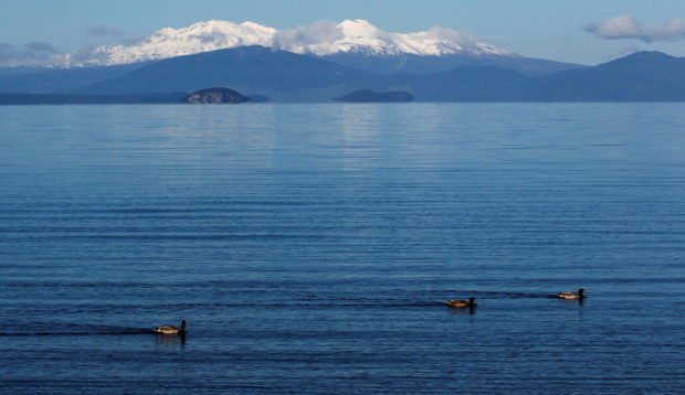 FILE PHOTO: The volcanic peaks of Mounts Tongariro, Ngarruhoe and Ruapehu rise over the shores of Lake Taupo September 28, 2011. REUTERS/Mike Hutchings/File Photo