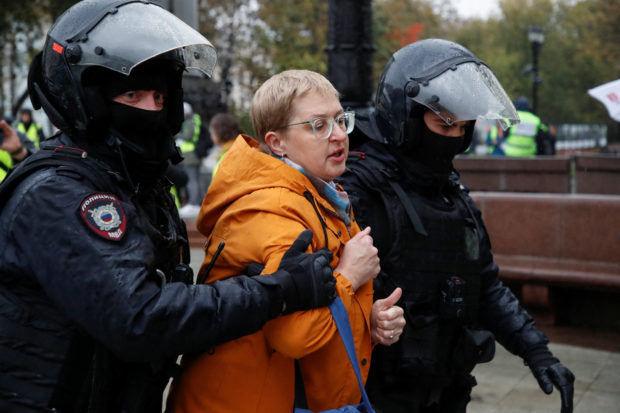 Russian law enforcement officers lead away a person during a rally, after opposition activists called for street protests against the mobilisation of reservists ordered by President Vladimir Putin, in Moscow, Russia September 24, 2022. REUTERS/REUTERS PHOTOGRAPHER