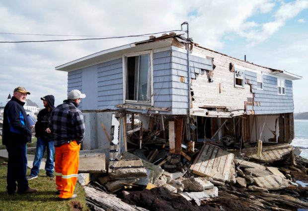 People examine the remains of a house after the arrival of Hurricane Fiona in Port Aux Basques, Newfoundland, Canada September 25, 2022. REUTERS/John Morris