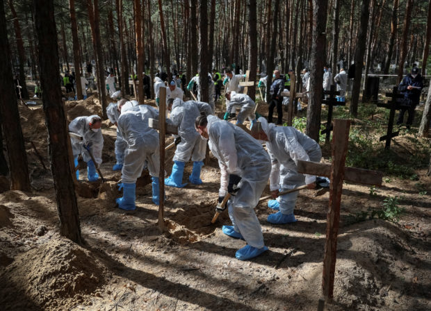 FILE PHOTO: Members of Ukrainian Emergency Service work at a place of mass burial during an exhumation, as Russia's attack on Ukraine continues, in the town of Izium, recently liberated by Ukrainian Armed Forces, in Kharkiv region, Ukraine September 19, 2022.  REUTERS/Gleb Garanich