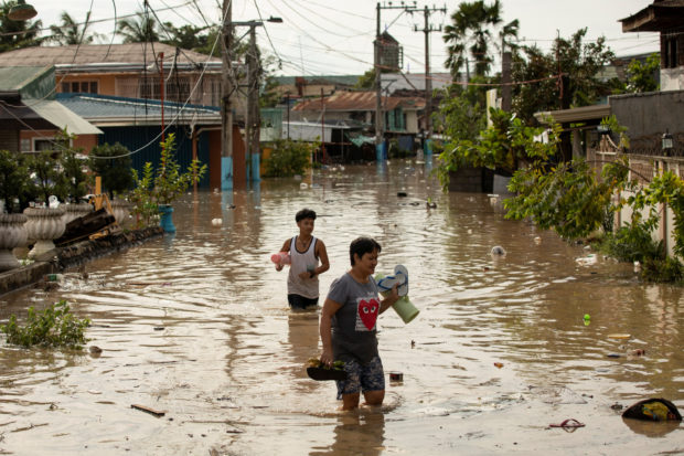 Residents wade through waist-deep flood waters after Super Typhoon Noru, in San Miguel, Bulacan province, Philippines, September 26, 2022. REUTERS/Eloisa Lopez