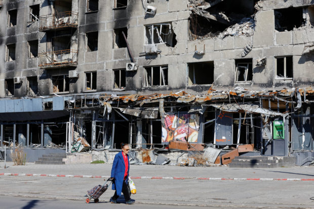 A local resident walks past an apartment block damaged in the course of Russia-Ukraine conflict in Mariupol, Ukraine September 25, 2022. REUTERS/Alexander Ermochenko