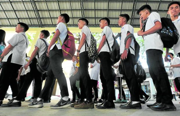 Junior high school students rehearse for their “moving up” program at Manila’s Araullo High School 