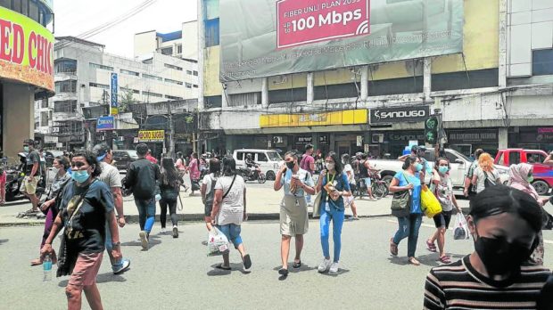 People walking along Colon Street in Cebu City on Thursday continue to wear face masks