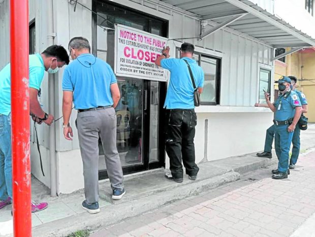 Personnel of the Iloilo city government’s Investment Services Business Permit and License Division close at least 26 water refilling stations last week after water samples from these establishments were found positive for coliform and E. coli in lab tests. STORY: Iloilo City declares state of calamity amid surge in cholera, gastro cases