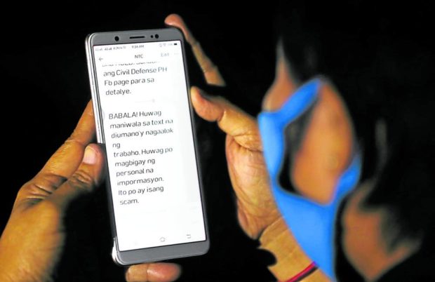Closeup of hands holding up a cell phone. STORY: Salceda suspects contact tracing as source of data leak