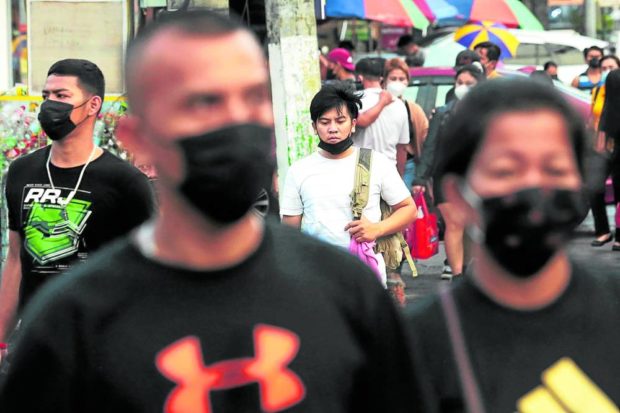 The government on Monday announces the easing of face mask use in outdoor and well-ventilated spaces in the country. On Kamuning Road, Quezon City, most people seen crossing the street keep their masks on as Filipinos start to learn to live with COVID-19. —GRIG C. MONTEGRANDE. FOR STORY: Okay to take off masks outdoors – Bongbong Marcos EO