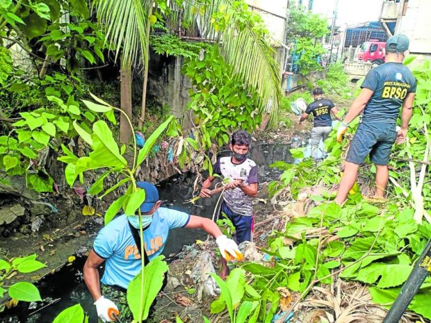 Central Visayas police officers and personnel conduct a cleanup drive in one of the rivers of Cebu City on Sept. 15