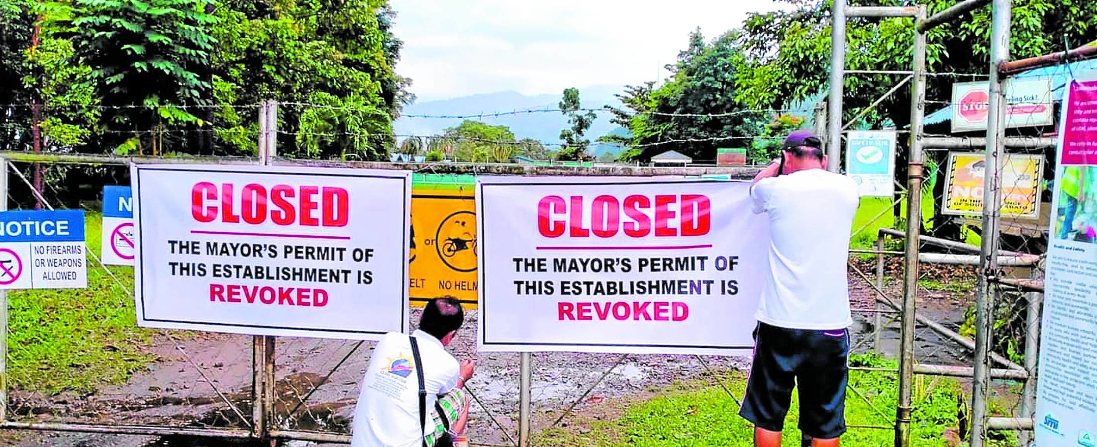 Workers of the Tampakan local government put a notice of closure on the entry to the core farm of Sagittarius Mines Inc. in Barangay Liberty