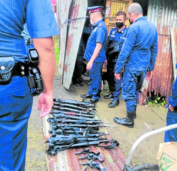 Policemen on Monday prepare to document the firearms seized from men encamped along a road in the vicinity of Masungi Georeserve in Rizal province STORY: Police seize guns from group occupying Masungi Georeserve
