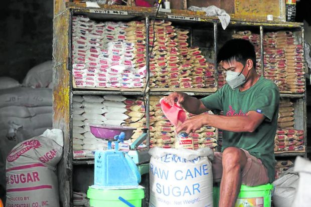 A store helper repacks washed sugar at Tandang Sora Public Market in Quezon City. STORY: Lawmaker seeks abolition of SRA