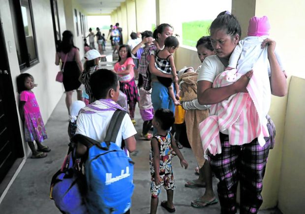 FRENZY OF PREPARATIONS Some 140 residents from Barangay San Rafael 3 in Noveleta, Cavite province, are evacuated to San Rafael Elementary School on Sunday morning, as the storm was on its way to Luzon island. —RICHARD A. REYES