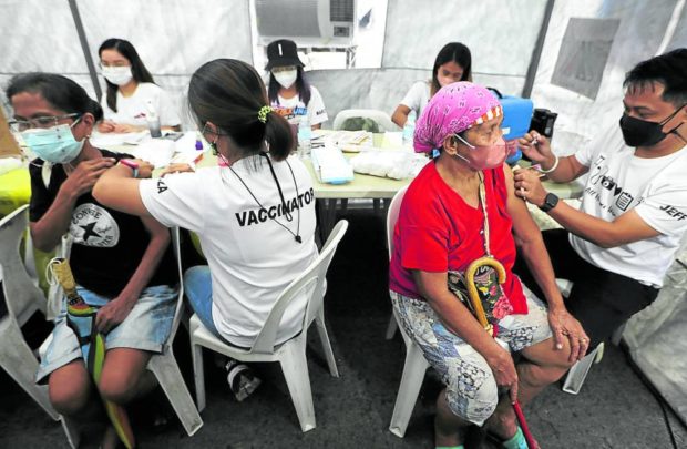 ADDED PROTECTION  Market vendors receive their booster shots during the Department of Health’s COVID-19 vaccination drive at Commonwealth Market in Quezon City on Aug. 30.  —NIÑO JESUS ORBETA