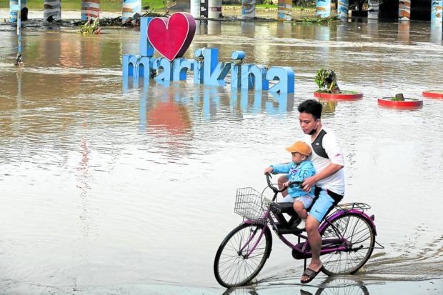 RIVER WATCH Rains dumped by “Karding” caused the Marikina River in Marikina City to overflow early Monday. —NIÑO JESUS ORBETA